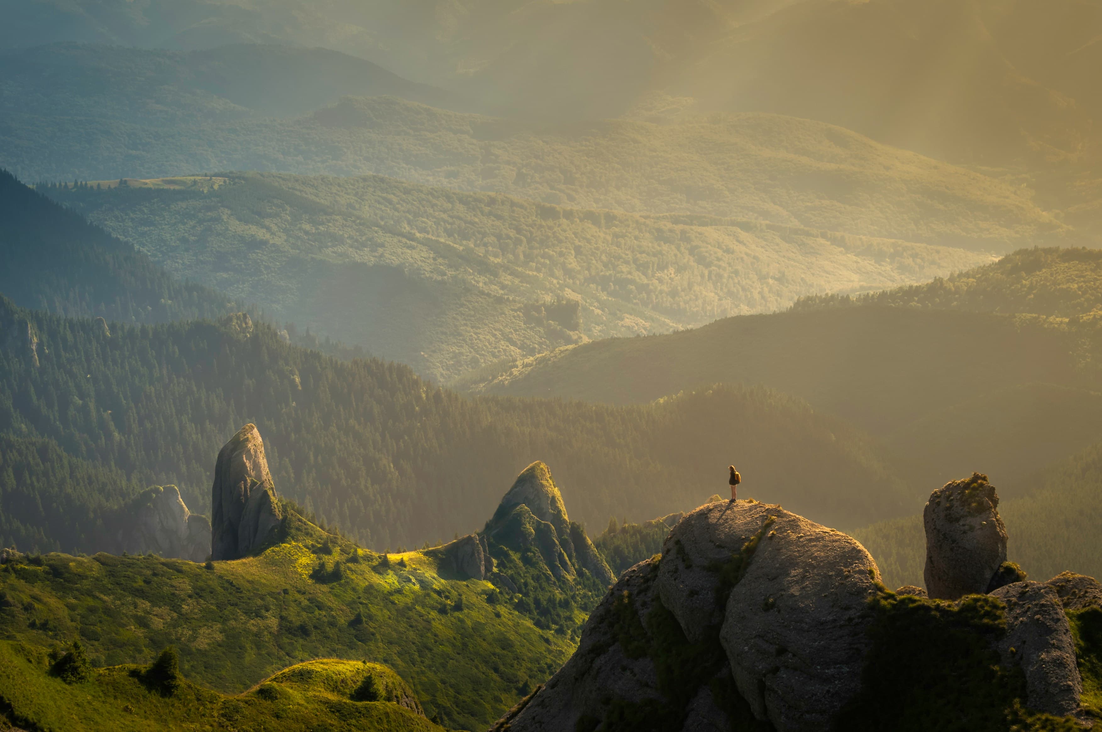 Cordillera montañosa al amanecer, con un viajero contemplando el valle — paisaje de aventura